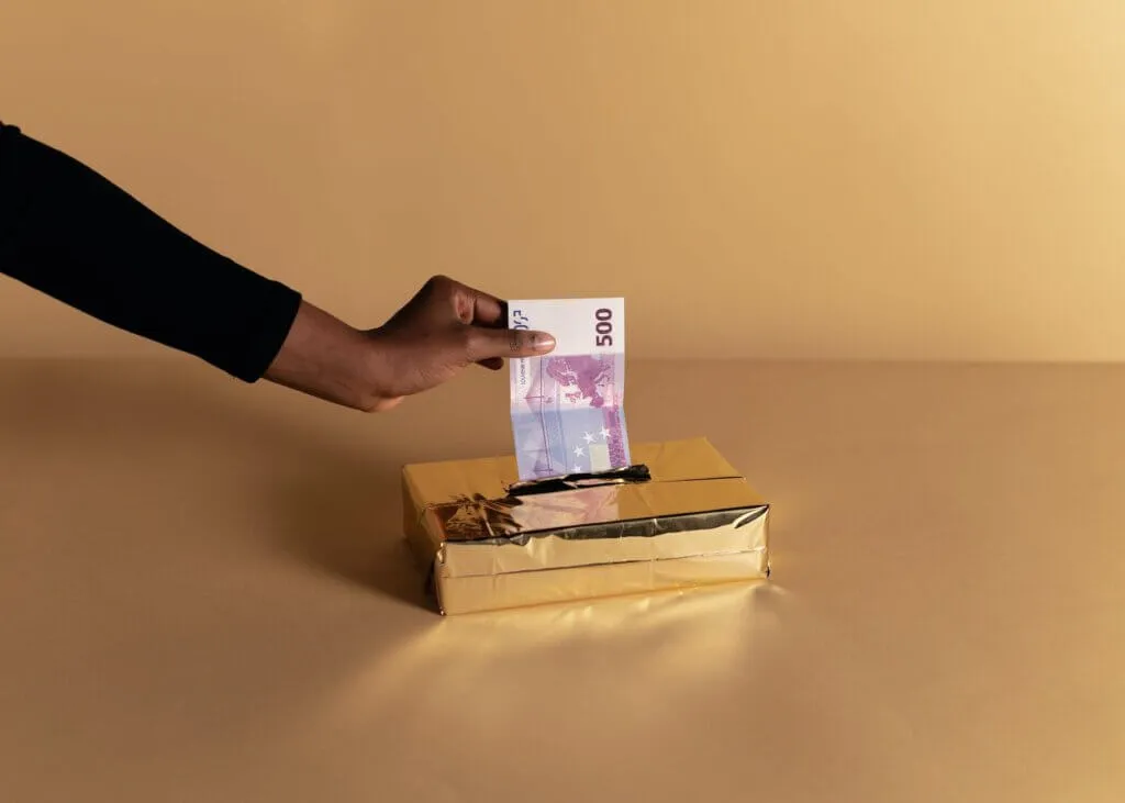 These Are All The Commercial Banks In Nigeria, According To CBN 8 person putting money inside the gold box