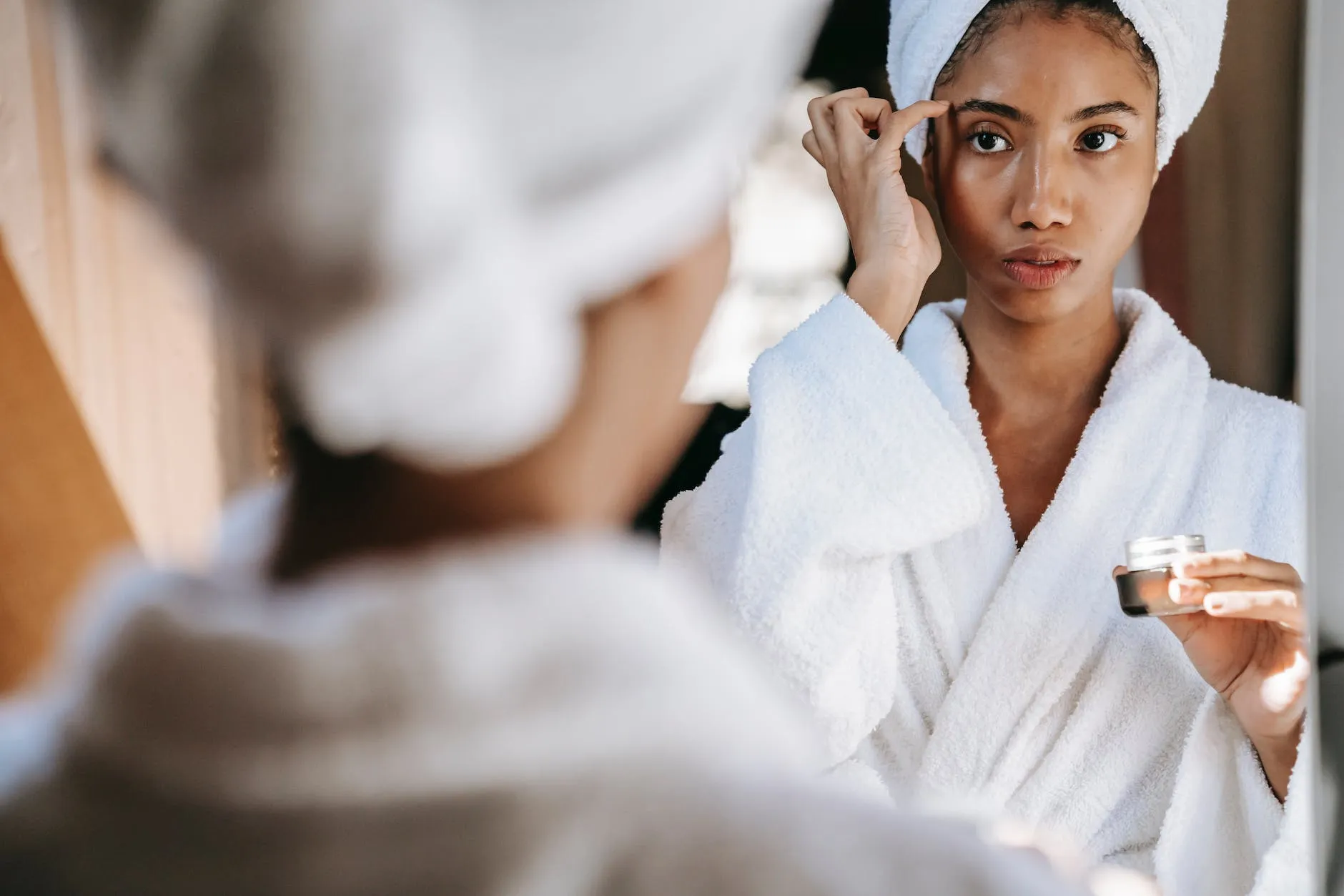 What Is Microneedling And How Does It Work? 11 woman rubbing cream on face after bath preping for Microneedling