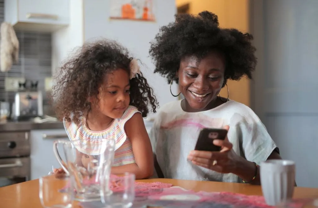 To Check 9mobile Data Balance In 2025 8 A mother teaching her daughter to check data balance in 9mobile