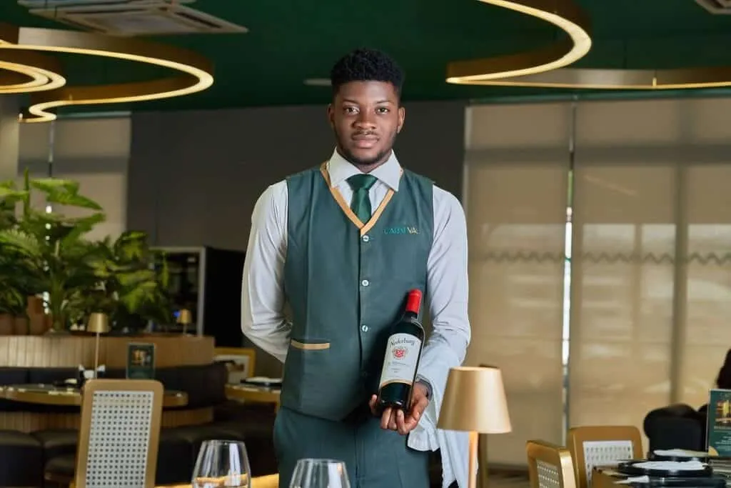 10 Must-Visit Date Night Restaurants In Abuja 5 A waiter servicing wine at Carneval restaurants