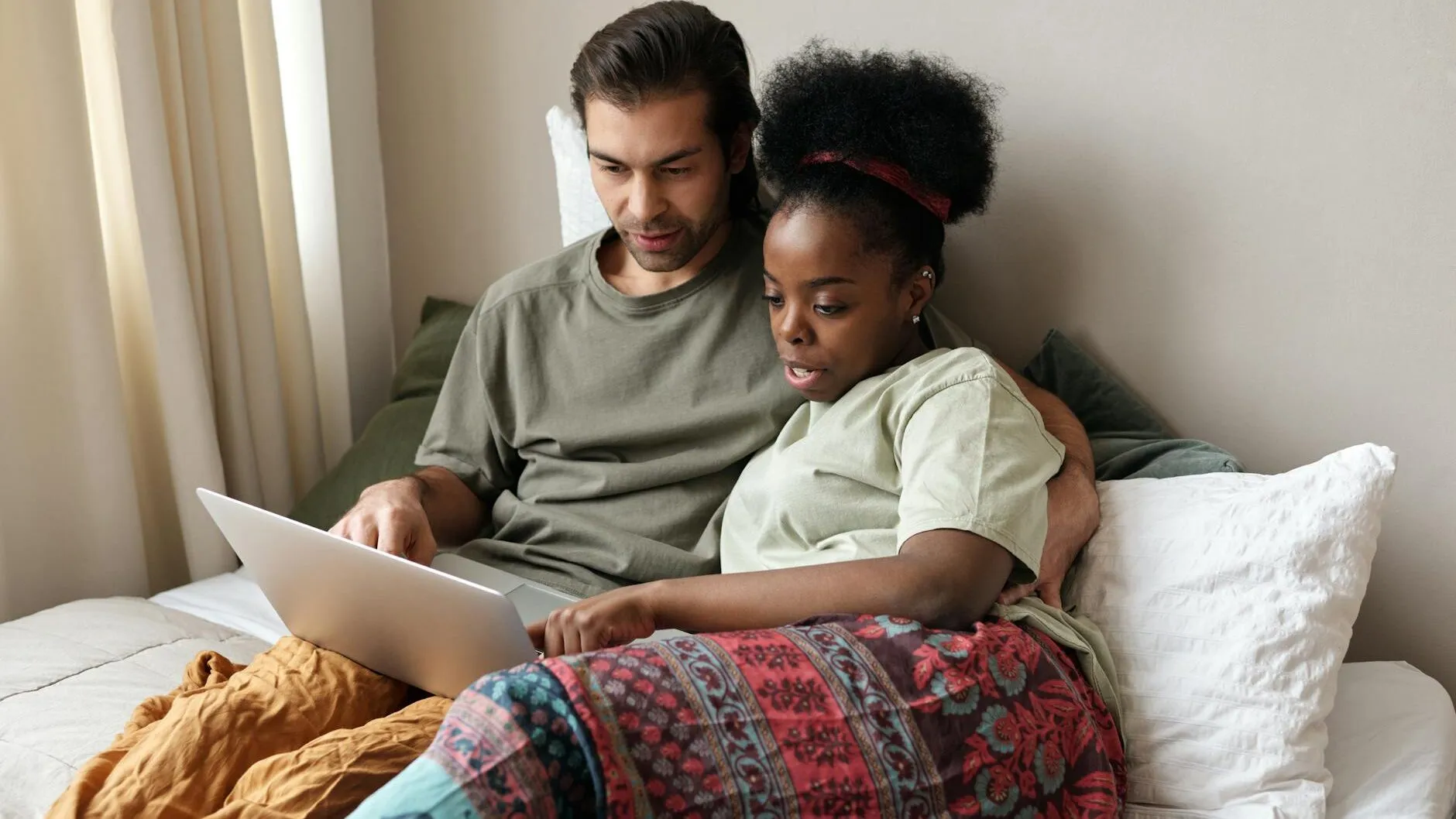 couple with a laptop in bed